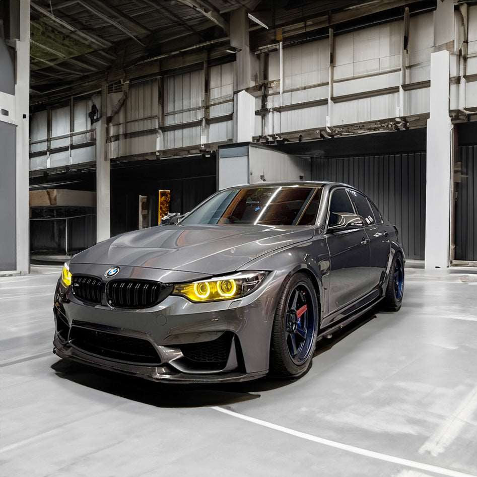 Grey bmw car with yellow headlights in a warehouse setting